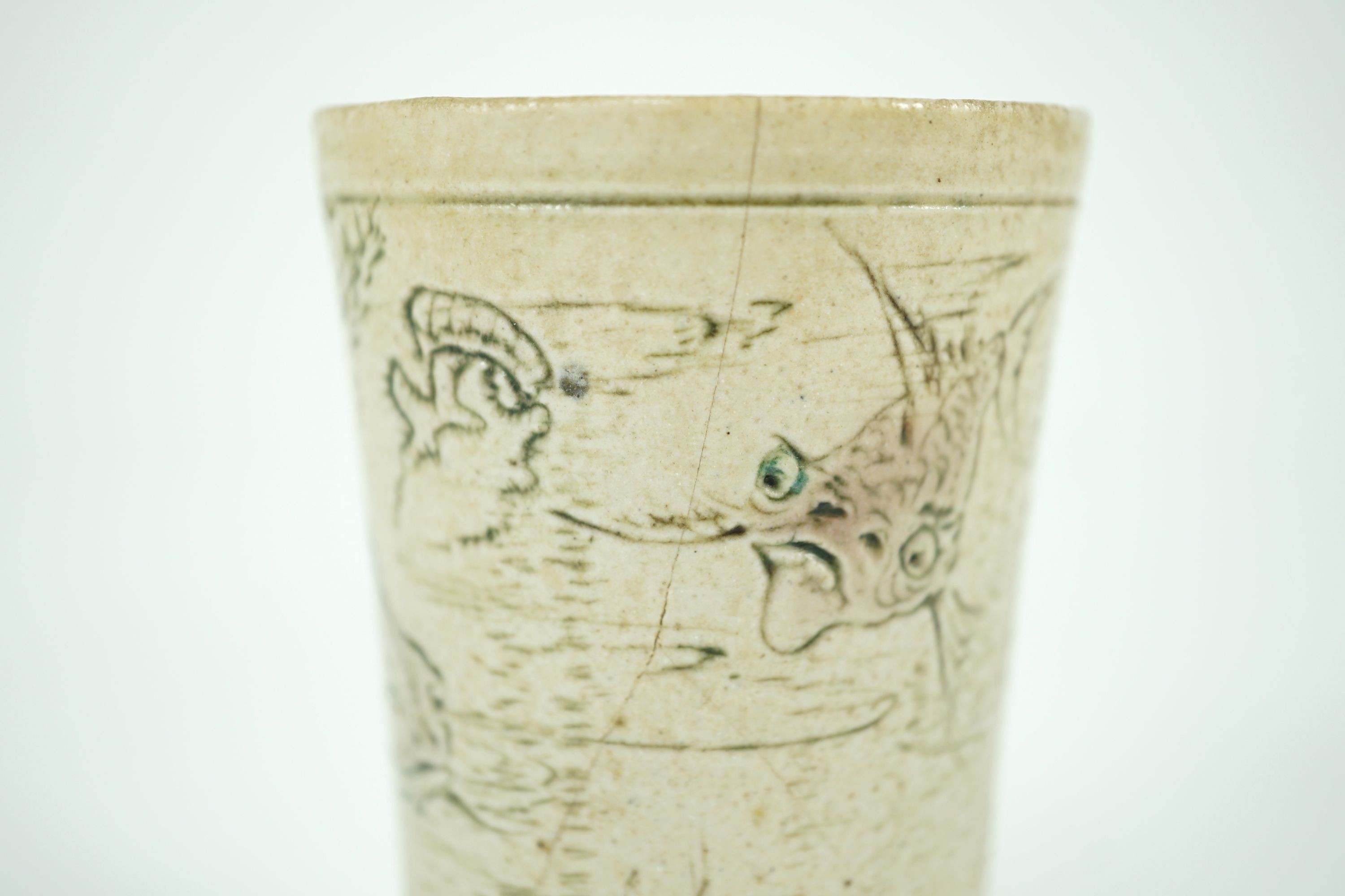 A Martin Brothers ‘grotesque fish’ beaker, dated 1914, 8.7cm high, hairline crack